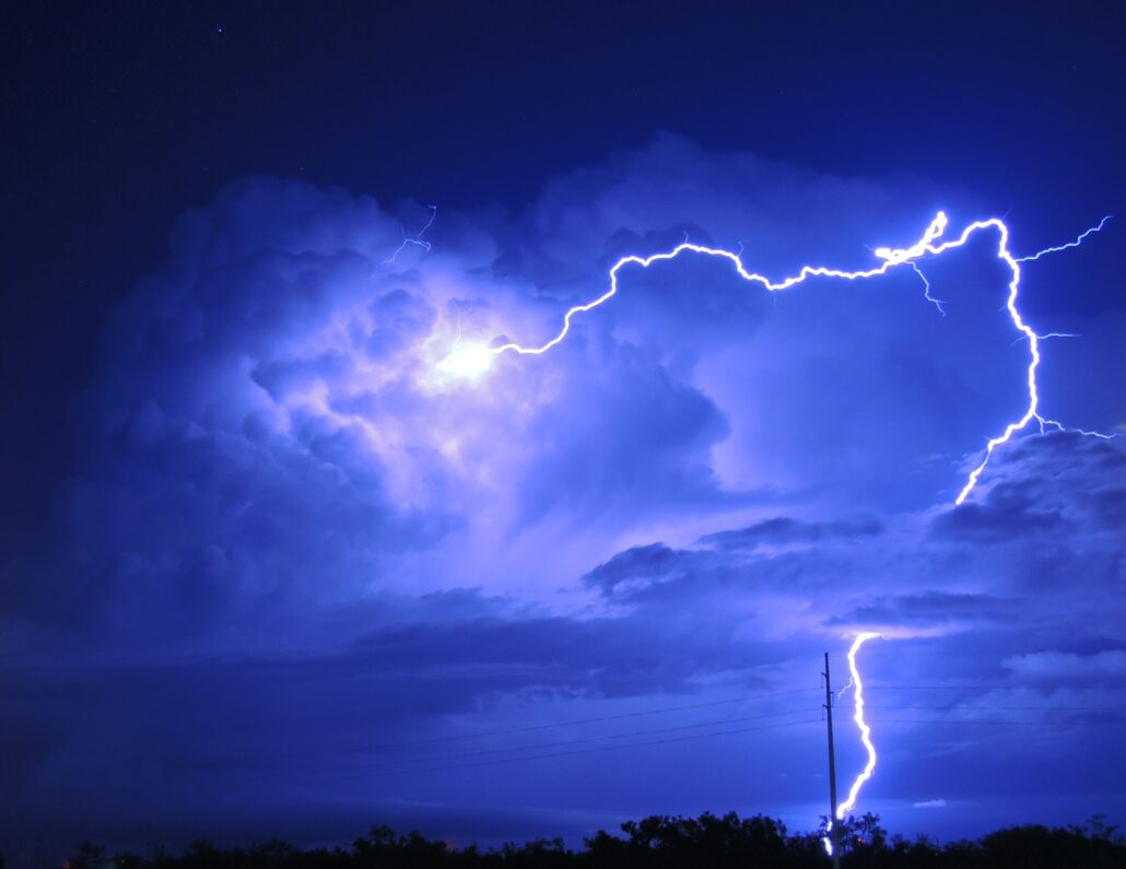 Dramatic lightning striking dark storm clouds at night, illustrating the potential dangers of severe weather related to property damage and insurance claims.
