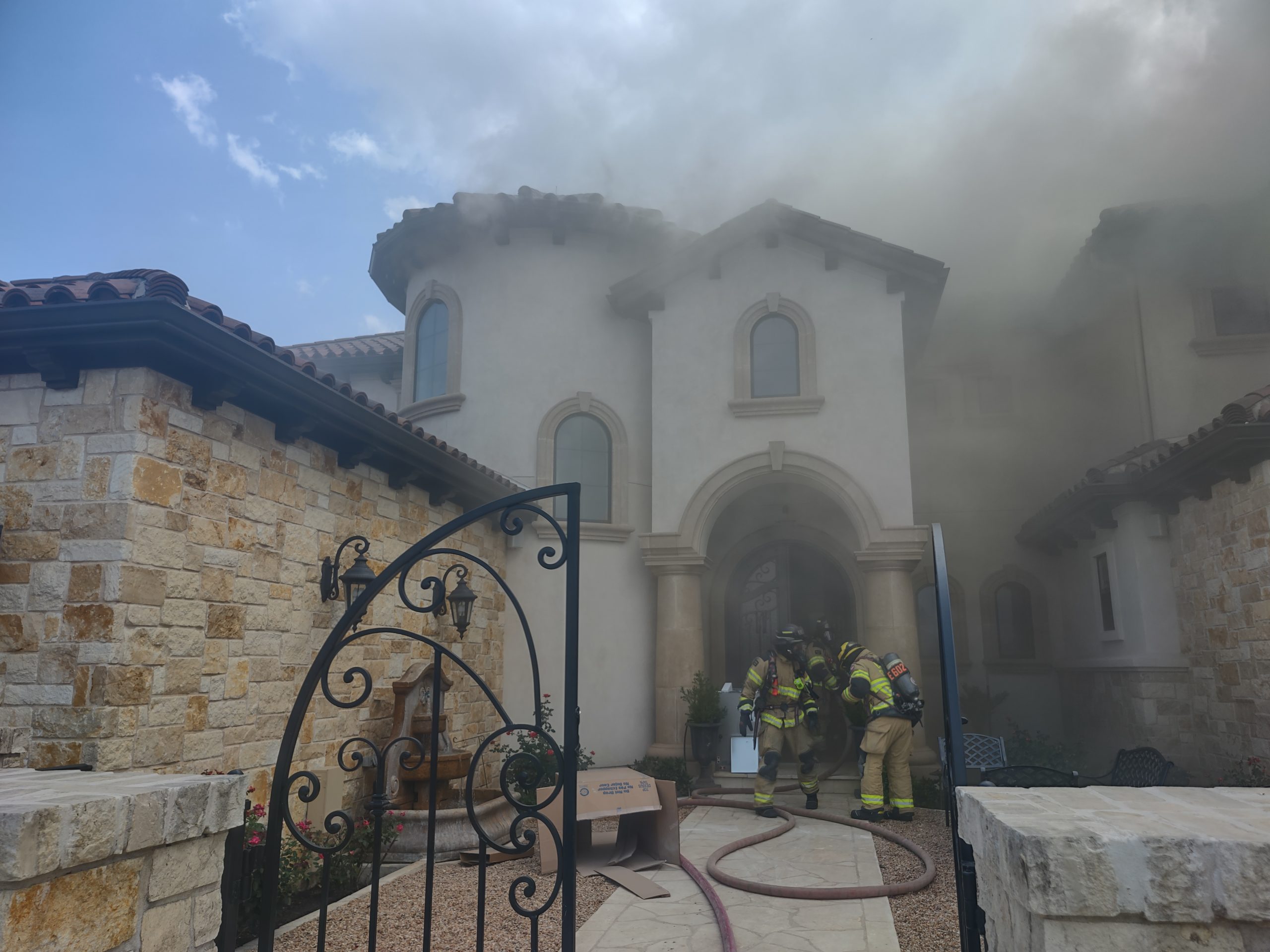 Firefighters and smoke at a residential property during emergency response