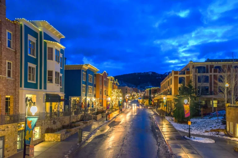 Park City Main Street at dusk with illuminated storefronts
