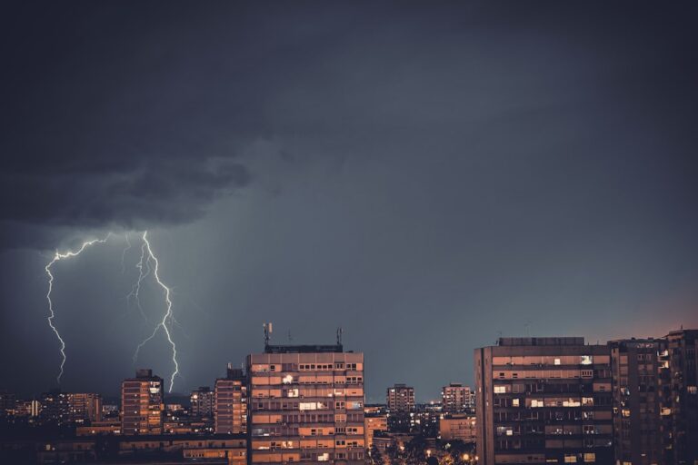 lightning striking commercial high-rise building at night