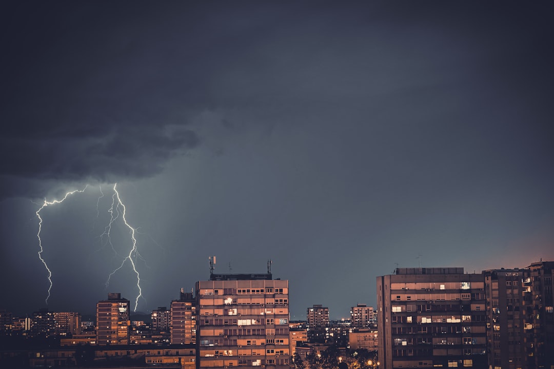 lightning striking commercial high-rise building at night
